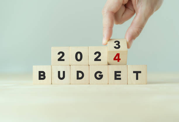 2024 年の予算計画と割り当てのコンセプト。木製の立方体を手でひっくり返し、「budget 2023」という碑文を灰色の背景、コピー用スペースの「budget 2024」に変更します。バナーやプレゼンテー� - 予算 ストックフォトと画像