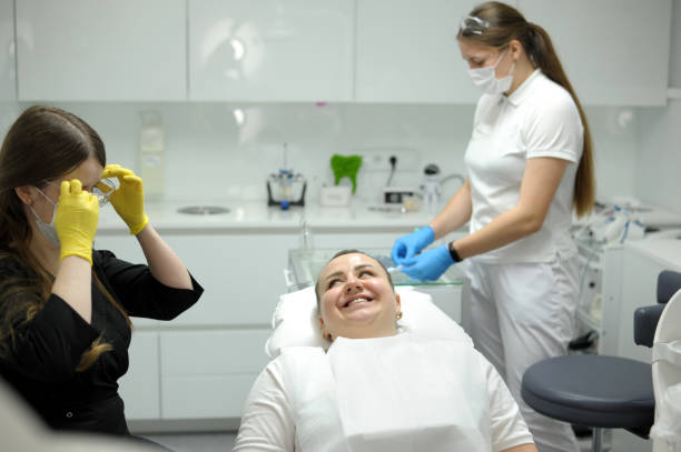 mujer encantada positiva sentada en el gabinete de su dentista mientras hace un chequeo - dental issues fotografías e imágenes de stock