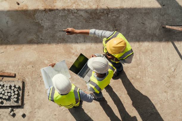 vista dall'alto, l'ispezione degli edifici dell'ingegnere del team utilizza il tablet e il progetto che lavora in cantiere. - engineer construction architect built structure foto e immagini stock