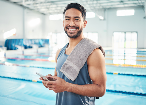 Portrait, swimming pool or man with smartphone, smile or connection for social media, typing or break. Face, male swimmer or athlete with cellphone, communication or share post with healthy lifestyle