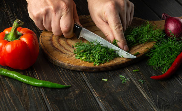 istock The chef cuts green fresh dill on a cutting board with a knife. Vegetarian menu for restaurant or hotel. 1485998597