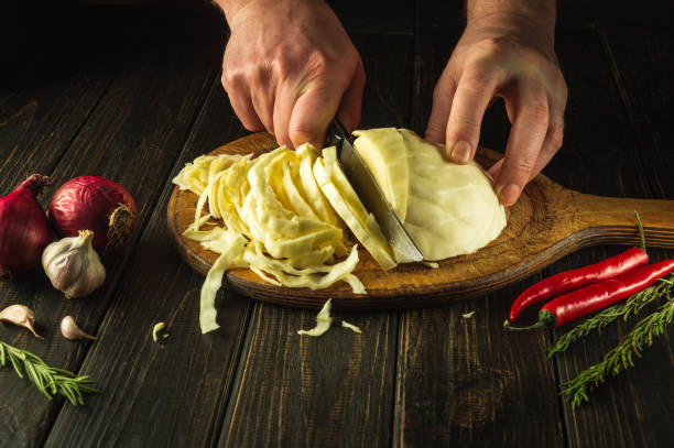 istock The chef cuts fresh cabbage for salad with a knife on a vintage kitchen table with fresh vegetables. The concept of cooking delicious diet food 1485999801