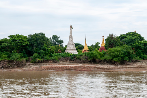 Irrawaddy River, Mandalay, Myanmar - nov 4, 2012 : stupas and pagodas appear among the vegetation on the banks during navigation on the Irrawaddy River between Mandalay and Bagan