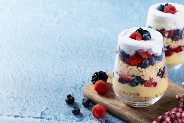 istock Trifle dessert with berries and cream on blue background 1486000299