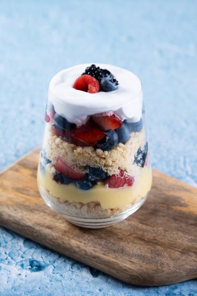 istock Trifle dessert with berries and cream on blue background 1486000342