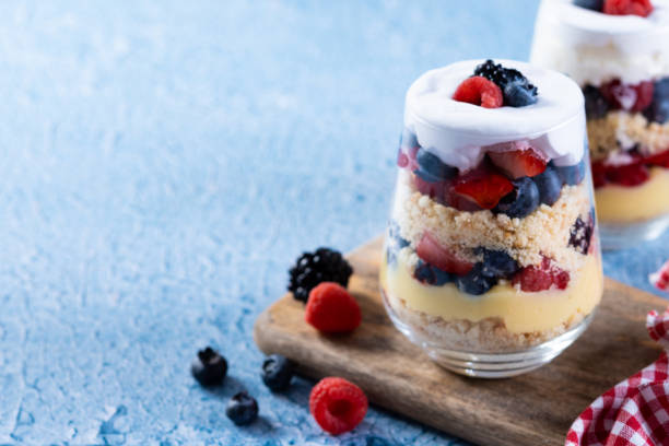 istock Trifle dessert with berries and cream on blue background 1486000374