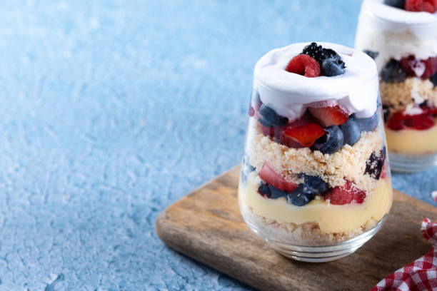 istock Trifle dessert with berries and cream on blue background 1486000423