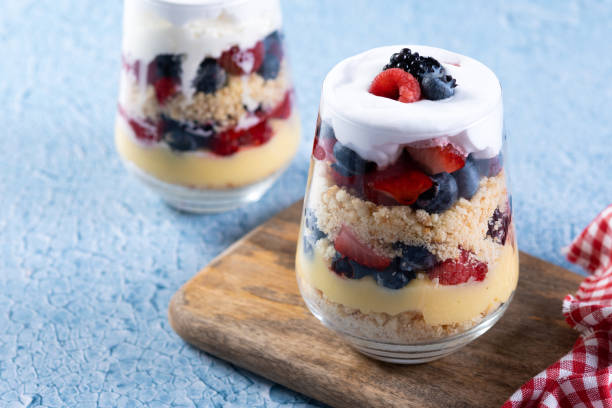 istock Trifle dessert with berries and cream on blue background 1486000438