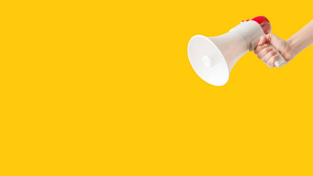 istock Megaphone in woman hands on a yellow background. 1486004023