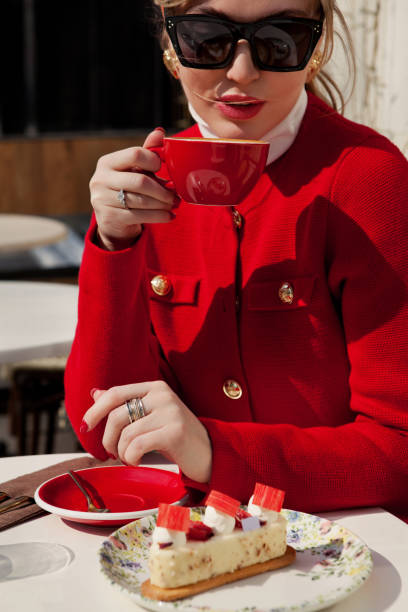 Stylish woman with red nails drinks cappuccino coffee and eats cake in cafe. Close up Elegant girl with cup of coffee wears red blazer jacket Portrait Stylish woman in sunglasses and red blazer drinks cappuccino coffee and eats cake in street cafe. Close up Elegant girl with cup of coffee cake models stock pictures, royalty-free photos & images