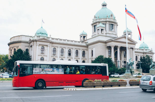 um ônibus vermelho em frente ao prédio do parlamento nacional sérvio - serbian flag - fotografias e filmes do acervo