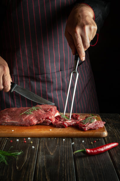 istock An experienced chef prepares raw fresh beef meat for roasting or barbecue. Working environment in the kitchen of a restaurant or hotel. 1486005900