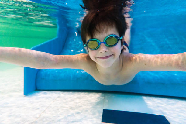istock Cute boy is swimming underwater in the pool 1486011531