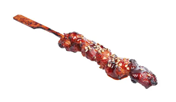 Delicious skewer of teriyaki chicken over isolated white background