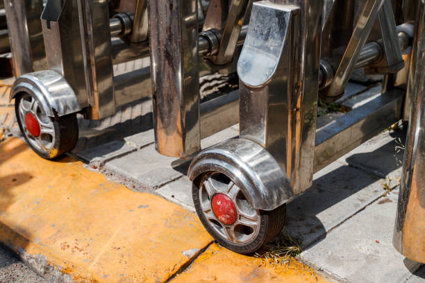 Metal and rubber transport caster wheels with blue rims displayed at a tool market, components for carts and industrial equipment.