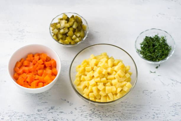 istock Bowls with diced potatoes, carrots, onions and dill on a light blue background, top view. Stage of cooking delicious healthy vegan dish 1486016842