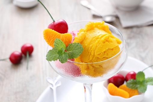 Fruit flavored ice cream scoop topped with mint leaves