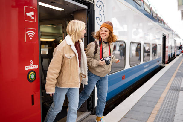 istock Happy female tourists talking while leaving the train at the station. 1486020665