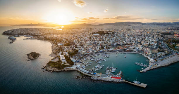 vue aérienne du coucher de soleil sur le quartier du pirée à athènes, en grèce, avec mikrolimano et zea marina - ferry terminal photos et images de collection