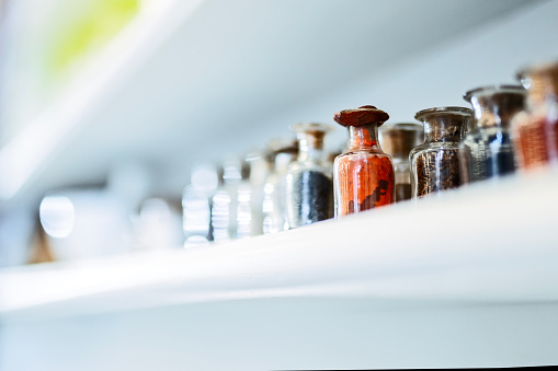 Chemicals for making medicine in historic pharmacy, glass bottles standing on shelves