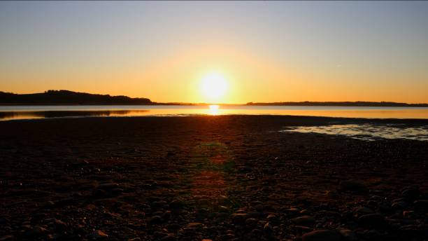 istock the sun is setting on the shore of a bay shore 1486022898