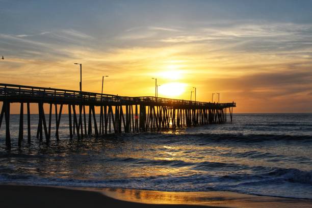 istock the pier extends into the ocean at sunset with clouds and bright sunlight 1486023735