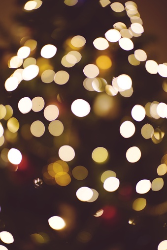 A vertical shot of golden bokeh lights, with a blurred background and a bright, luminous effect