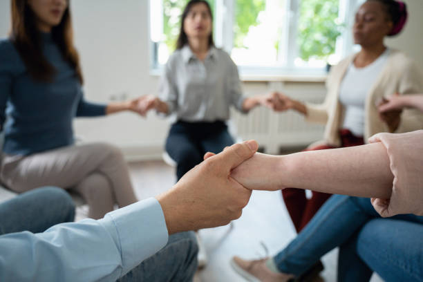 istock Multiracial group of women and men, having group therapy, while holding hands 1486027365