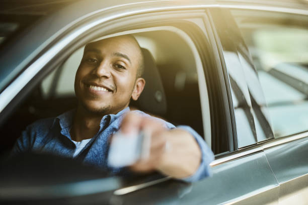 istock Happy black man with credit card driving a car. 1486032867
