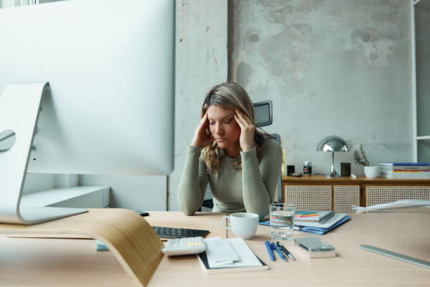 istock Tired businesswoman having a headache while working in the office. 1486033383