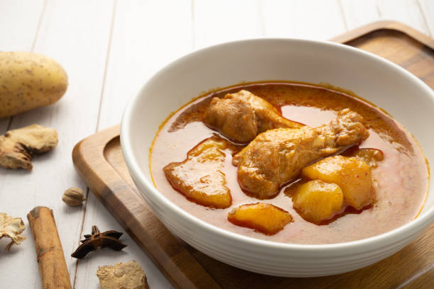 massaman di pollo con patate in ciotola bianca su tavolo di legno. - massaman foto e immagini stock