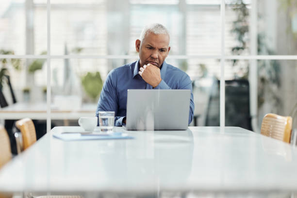 istock Hispanic senior businessman working on laptop in the office. 1486036465
