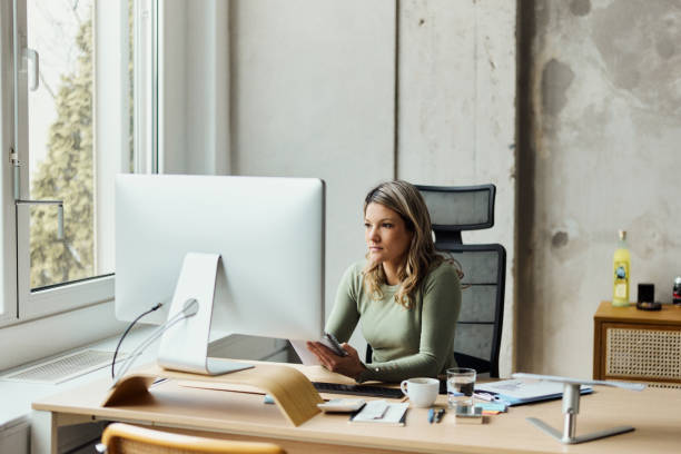 istock Young businesswoman working on plans and computer in the office. 1486037052