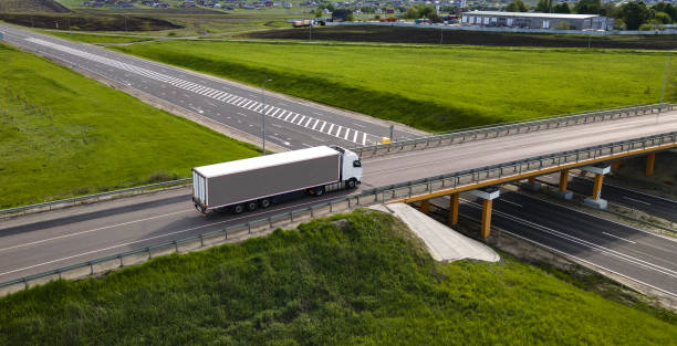 istock Truck with Cargo Semi Trailer Moving on Road in Direction. Highway intersection junction. Aerial Top View 1486037624