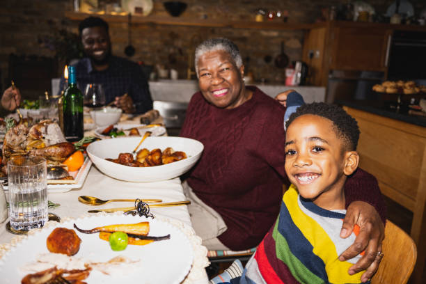 クリスマスランチで陽気な男の子と祖母 - dining table flash ストックフォトと画像