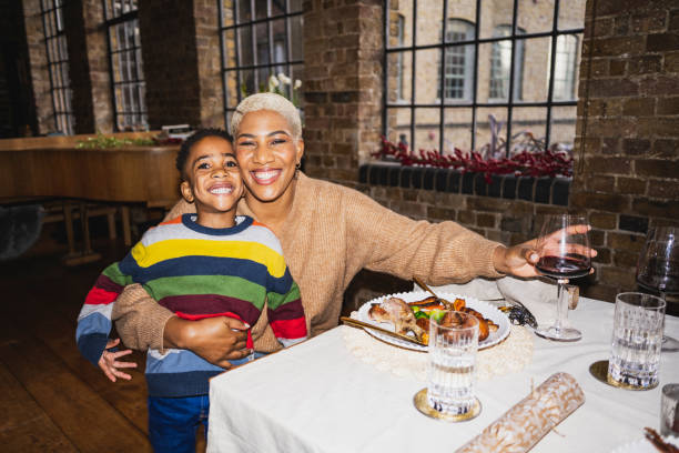 affectionate mother and young son at christmas lunch - happy kid flash imagens e fotografias de stock