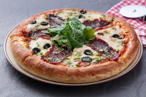 Delicious mixed pizza with bacon, olives , mozzarella, sausage. Italian food image.