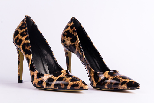 A pair of leopard heels on a white surface