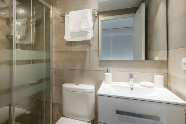 istock Conventional toilet with white resin sink, square mirror without frames and shower with screen 1486050192
