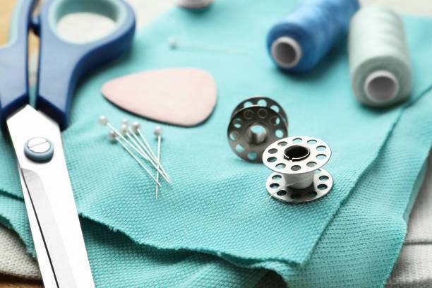 istock Scissors, spools of threads and sewing tools on cloth, closeup 1486051599