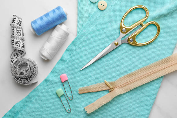 istock Threads and other sewing supplies on white marble table, flat lay 1486051608