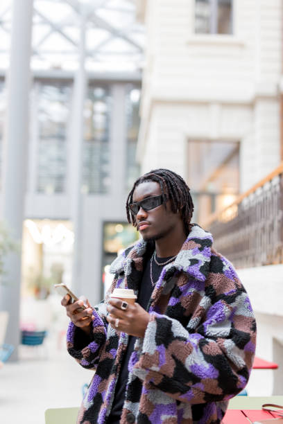 istock young man Afro using his phone and drinking a coffee 1486053672