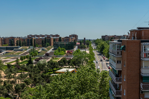 Views of facades of urban residential buildings from the heights next to a large park and gardens