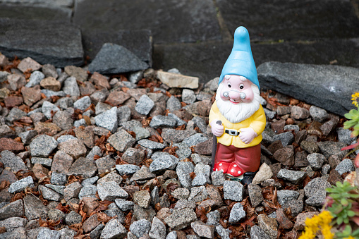 garden gnome with rake and orange pointed cap