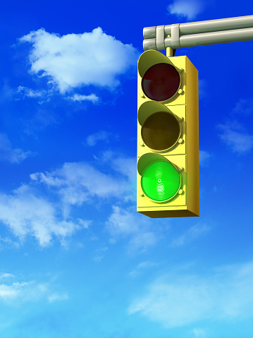 Red traffic light against blue sky.