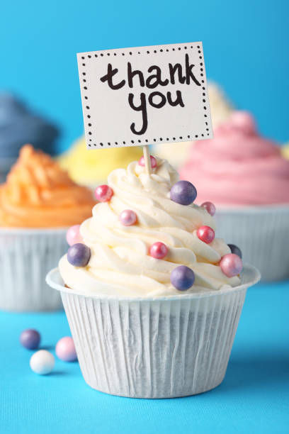 istock Tasty cupcakes and note with phrase Thank You on light blue background 1486055723