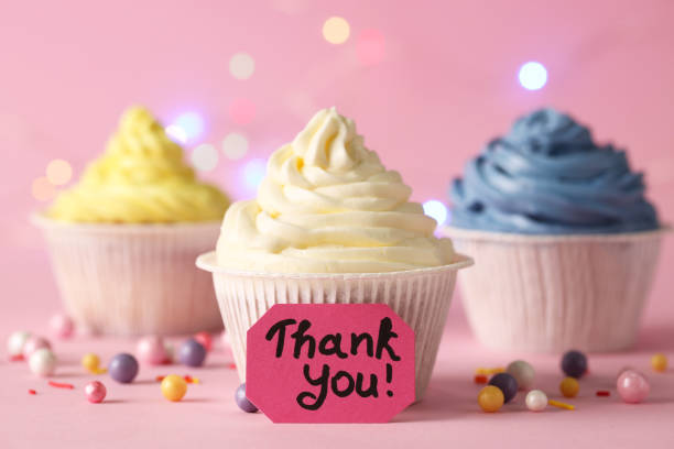 istock Tasty cupcakes and note with phrase Thank You on pale pink background 1486055781