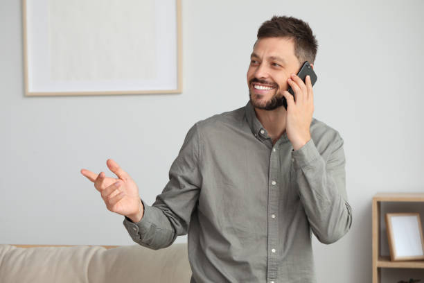 istock Happy man talking on smartphone at home 1486055927