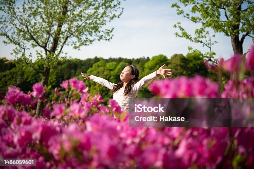 istock Girl open arms in flower garden 1486059601