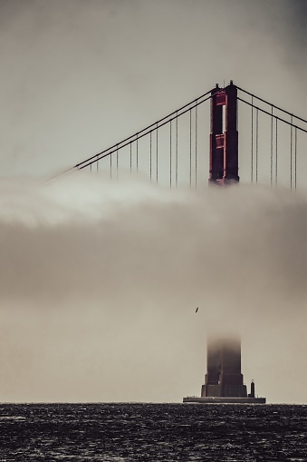 A scenic view of the iconic Golden Gate Bridge in San Francisco, California shrouded in a heavy fog
